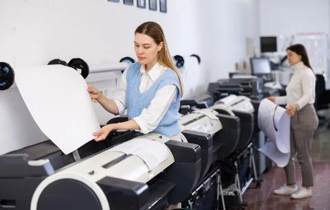 Print worker controlling printing process on modern offset machine in print shop Stock Photos