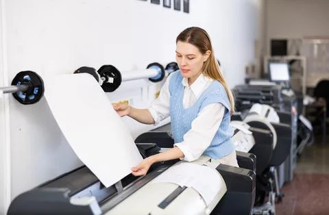 Print worker controlling printing process on modern offset machine in print shop Stock Photos