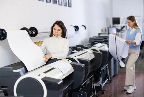 Print worker controlling printing process on modern offset machine in print shop Stock Photos