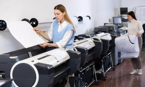 Print worker controlling printing process on modern offset machine in print shop Stock Photos