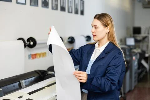 Print worker controlling printing process on modern offset machine in print shop Stock Photos