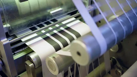 Printed label web moves through an automated converting machine during RFID and Stock Footage 348127809