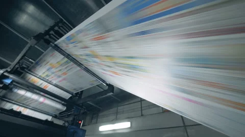 Printed newspaper going on a rolling conveyor, print office equipment. Stock Footage 107457571