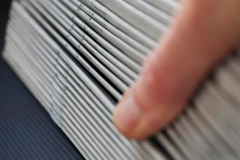 Printed newspapers thumbed through Stock Photos