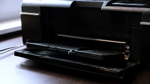 A printed paper sheet comes out of the color inkjet printer in close-up Stock Footage 314622045