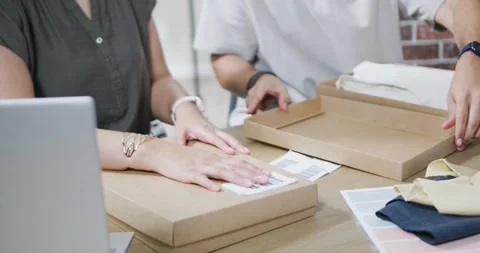 Printed shipping label is appearing on table while pair are labeling and packing Stock Footage 344654965