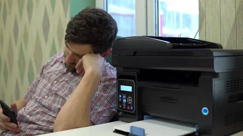 The printer on the desk printed two blank sheets of paper to the man next to him Video stock 146316970