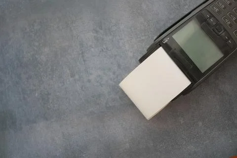 Printer dispensing blank labels on a grey background Stock Photos