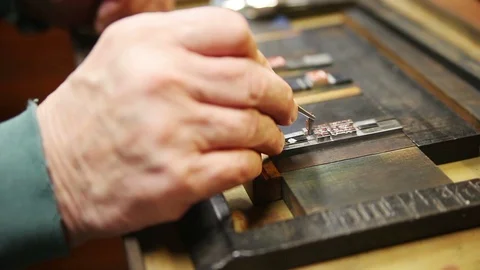 Printer moves small type with tweezers Stock Footage 99424551