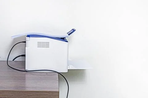 ?A printer on an office desk with a stack of paper on top. Stock Photos