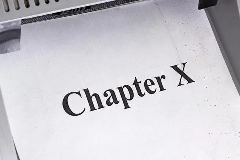 Printer outputs text showing Chapter X on a sheet of paper during a writing Stock Photos