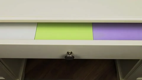 Printer papers of different colors are laid out in a desk drawer Video stock 295032768