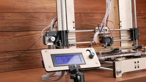 The printer prints the gear. The display shows information about nozzle Stock Footage 77950134