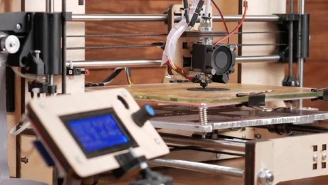 The printer prints the gear. The display shows information about nozzle Stock Footage 77951729