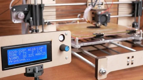 The printer prints the gear. The display shows information about nozzle Stock Footage