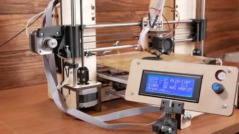 The printer prints the gear. The display shows information about nozzle Stock Footage 77953783