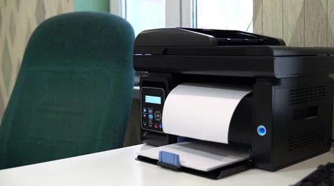The printer on the table has printed a blank sheet. Office space, table, chair Stock Photos