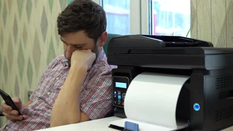 The printer on the table printed the word go to work to the man next to him. Man Stock Footage 146317245
