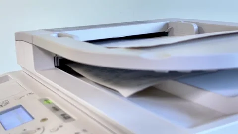 The printer takes documents from the upper tray for scanning and printing. Stock Footage 317453451