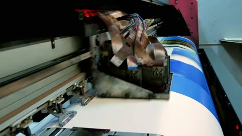 The printhead of a large-format inkjet printer moves along the banner material,  Stock Footage 230978724