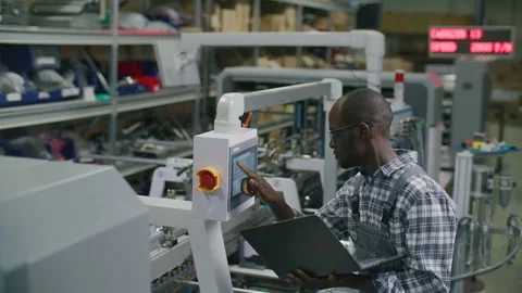 Printing Factory Engineer Using Laptop and Control Panel on Production Line Stock Footage 335486454