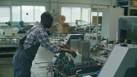 Printing Factory Worker Operating Automated Paper Processing Machine Stock Footage 335484596