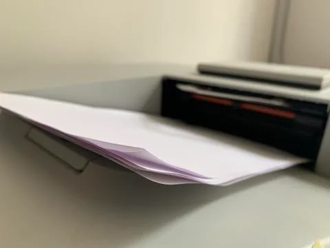 Printing paper is inserted in the printer. Printer for copying documents. Off Stock Photos