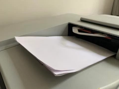 Printing paper is inserted in the printer. Printer for copying documents. Off Stock Photos