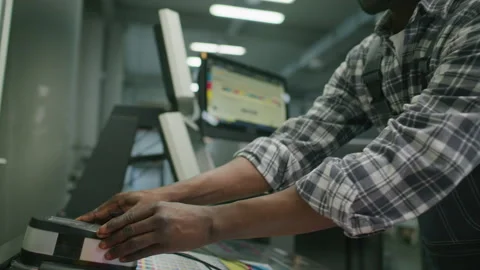 Printing Press Operator Scanning Color Chart with Spectrophotometer Stock Footage 335483297