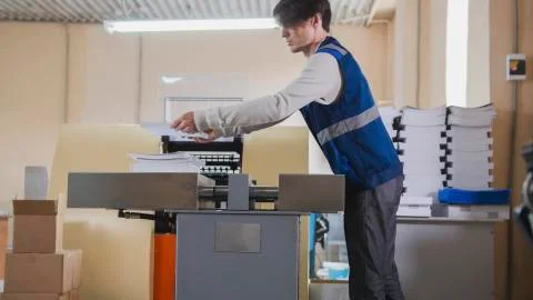 Printing process - feeding sheets of paper, polygraph industry, close up Stock Photos