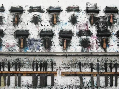 Printmaking rollers hanging on an art studio wall in the messy workshop Stock Photos