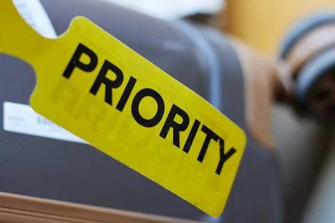 Priority Luggage Tag On Rolling Suitcase At Airport Emphasizing Travel Priority  Stock Photos