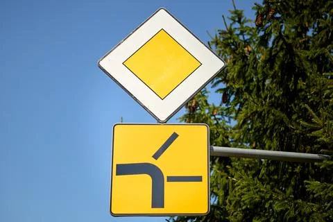 Priority road with side road merging from the left traffic sign Stock Photos
