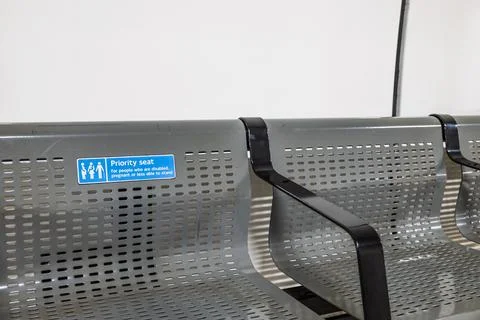 Priority seating sign on metallic bench in London Underground station Stock Photos