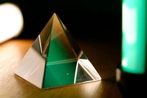 Prismatic pyramid standing elegantly with vibrant light reflections 库存照片
