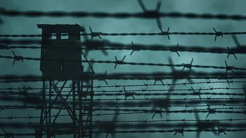 Prison barbed wire and a watchtower Stock Photos