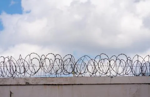 Prison Barbed Wire with cloud sky background Photos