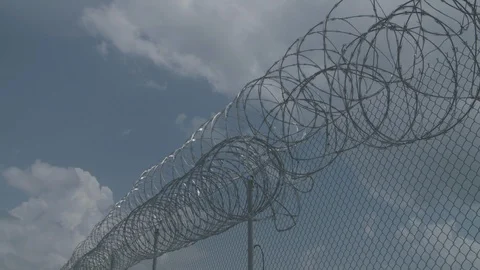 Prison Barbed Wires, with Fast Moving Clouds, Timelapse Stock Footage 89869323