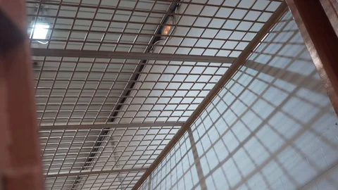 Prison bars and lanterns illuminating prison corridor. camera rotates slowly Stock Footage 120758901