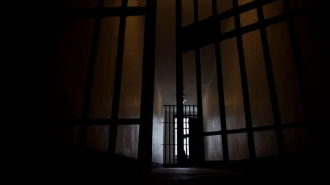 Prison Bars Closing in a Dark, Depressing and Lonely Looking Jail Cell in 4K Stock Footage