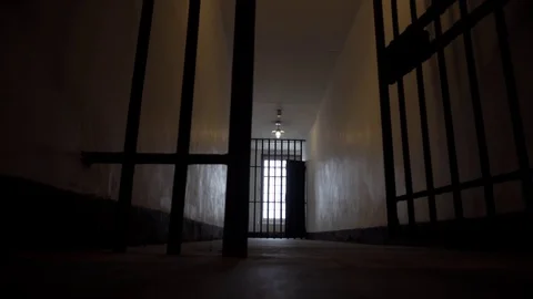 Prison Bars Open in a Dark and Lonely Looking Holding Jail Cell in 4K Stock Footage
