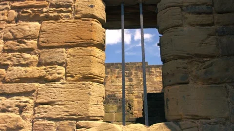 Prison bars on a stone wall Video stock 339707015