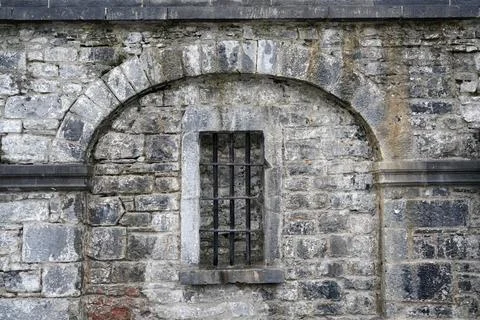 Prison bars on window in old stone wall Stock Photos