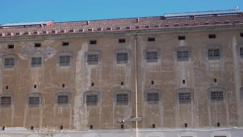 Prison building wall with bars on windows against clear sky 스톡 동영상 120039479