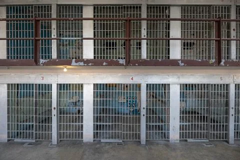 A prison cell block with bars on the windows and doors Stock Photos