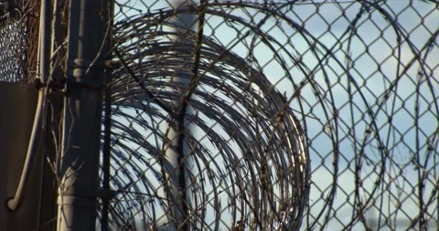 Prison, correctional facility. Razor wire on top of fencing. Stock Footage 143762547