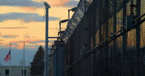 Prison, correctional facility, sunsetting, American Flag. Stock Footage 143759721