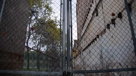 Prison gates with electric barbed wire closed with an old lock Stock Footage 165052504