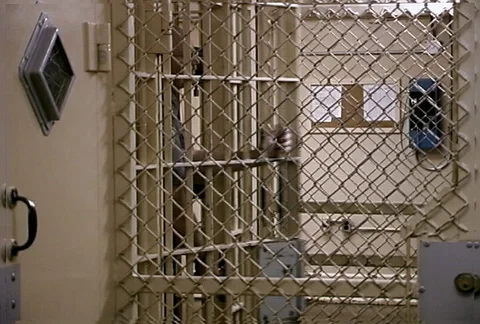 Prison guard exiting and locking a barred door 動画素材 86920015