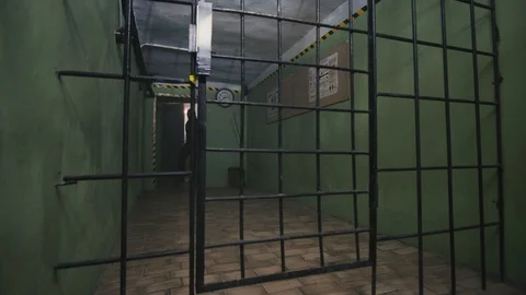Prison guard in special uniform is going through the metal gates, 4k Stock Footage 104043797